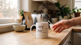 Christliche Tasse mit Bibelvers am Küchenfenster mit dampfendem Kaffee