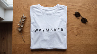 Christliches Shirt als Flatlay auf Eichenholz mit minimalistischem Print