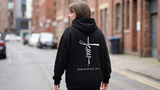 Person im oversized christlichen Hoodie mit Rückenprint auf der Straße