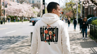 Person in christlicher Mode mit Hoodie-Rückenprint auf einer Frühlingsstraße