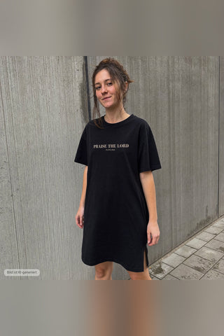 Praise the Lord T-Shirt Kleid schwarz, urbaner Look vor Betonwand (KI-generiertes Bild)