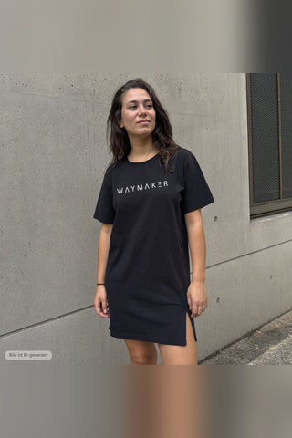Waymaker T-Shirt Kleid schwarz, urbaner Look vor Betonwand (KI-generiertes Bild)